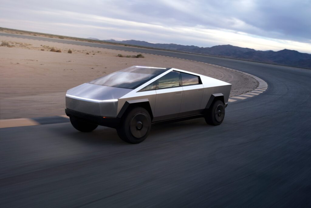 Perspective view of a Tesla Cybertruck driving around a track in the desert