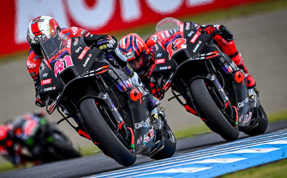 Two Aprilia motorbikes racing around a corner at Motegi