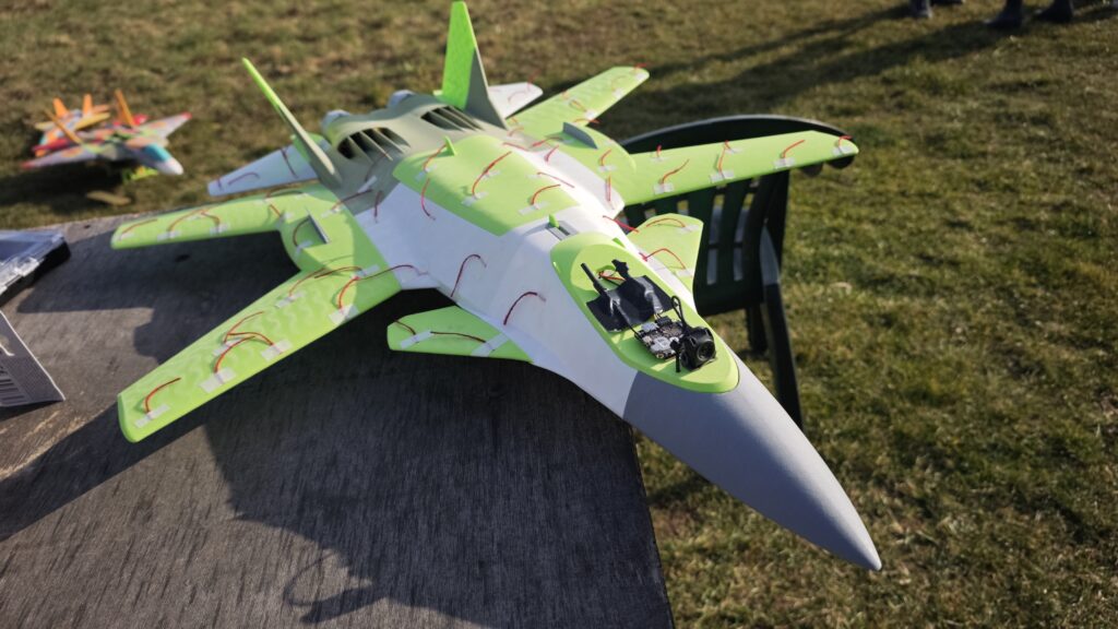 The real JRM-02XC40 RC model instrumented with red wool tufts in a field