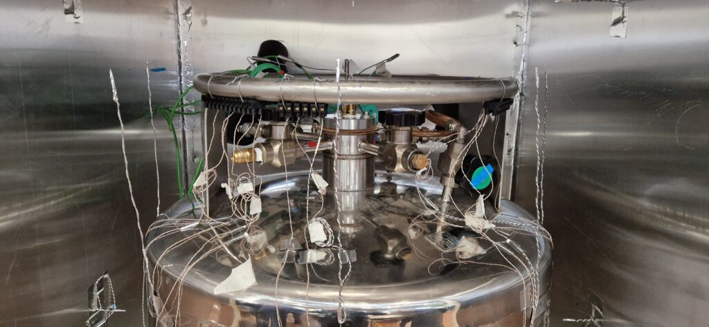 Cryogenic tank instrumented with sensors and wiring inside a test chamber, used for analysing LNG and liquid hydrogen storage performance in marine applications.